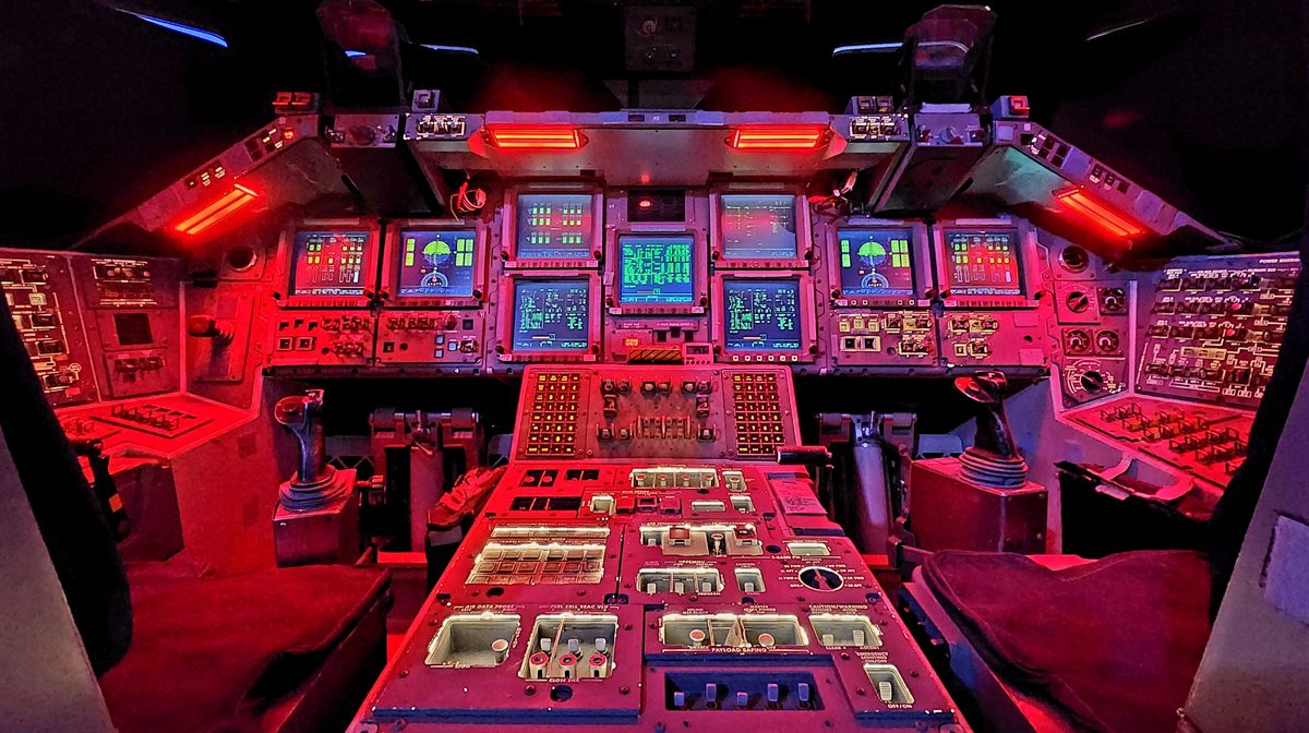 An aircraft cockpit full of instruments lit in red