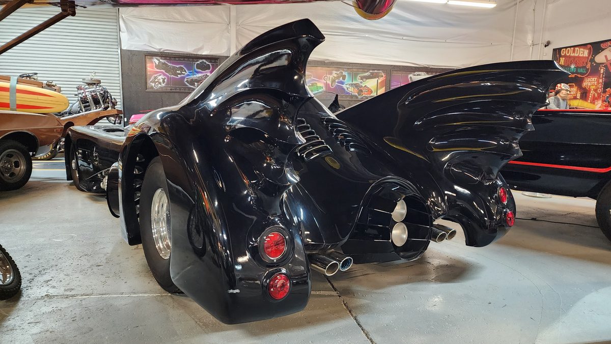A classic Batmobile replica on display in a car museum