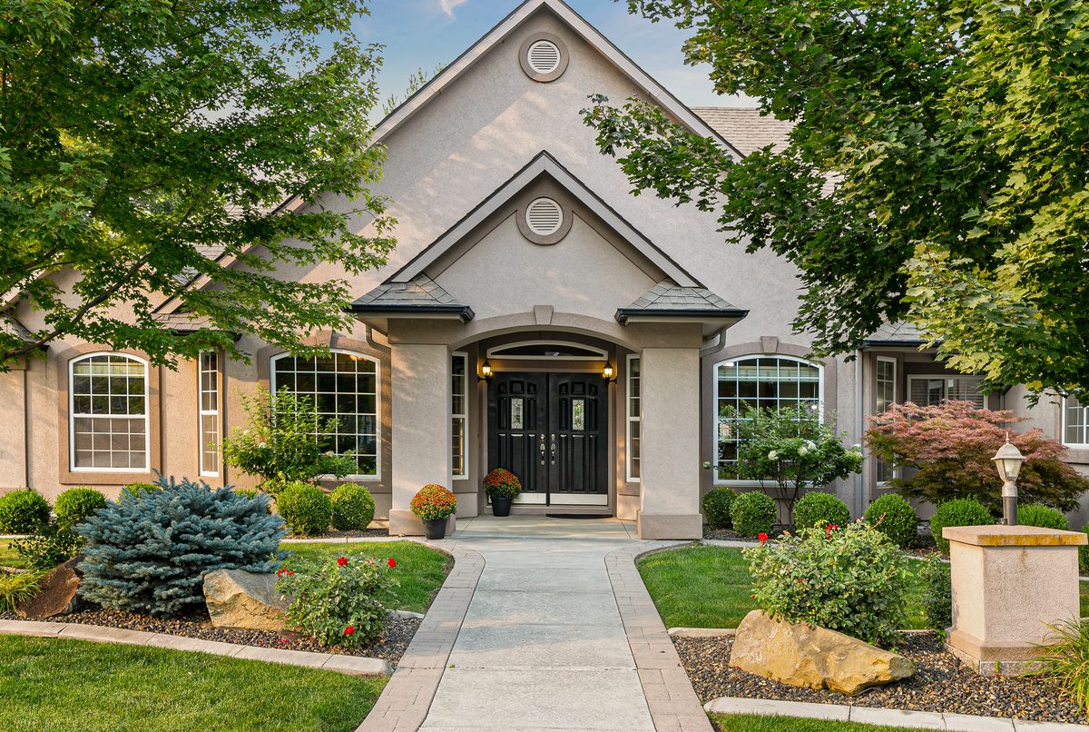 Brick home with an arched entry and a landscaped front walkway