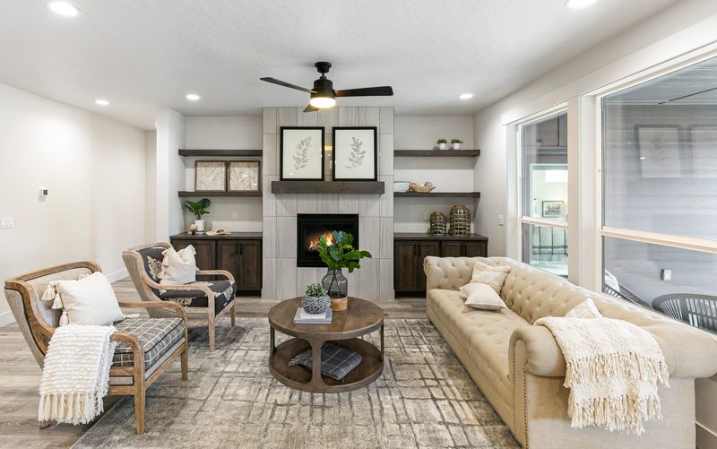 Living room with a cream sofa, built-in shelves, a fireplace and tall windows