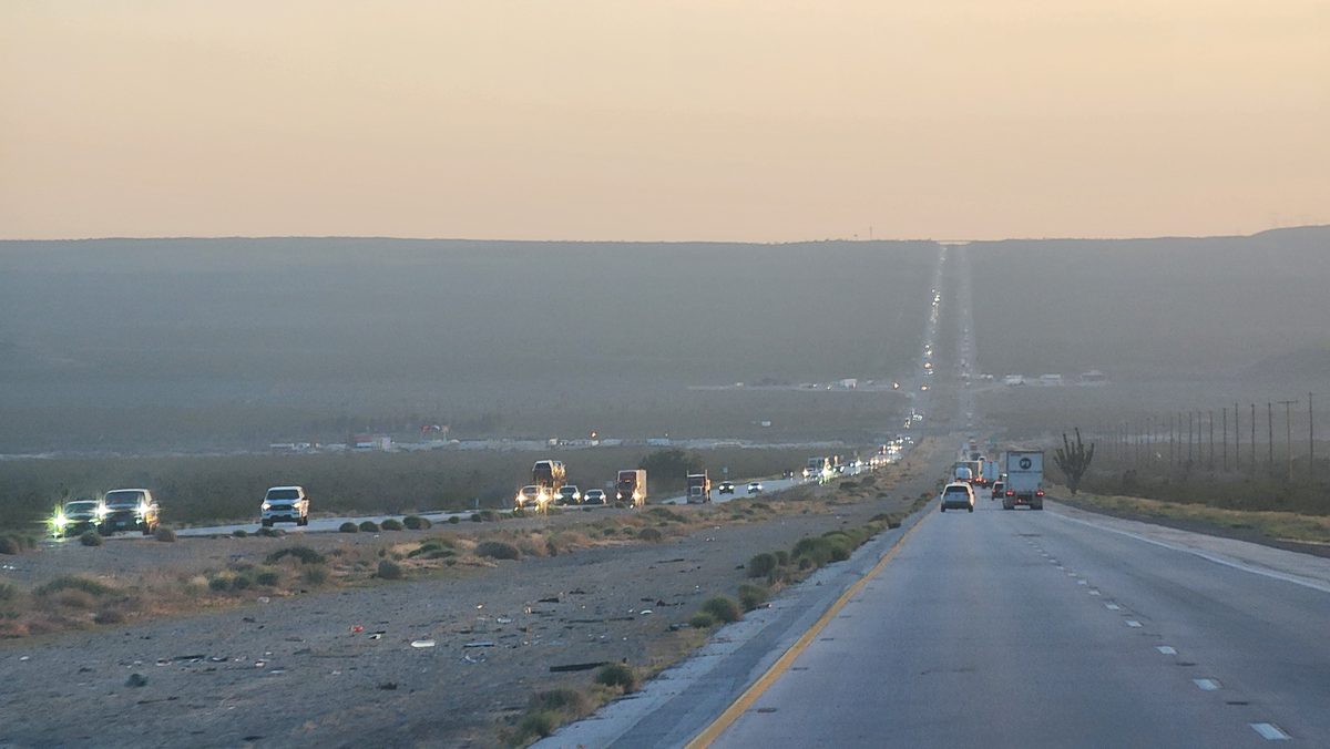 A long straight desert highway disappearing into the dusk haze