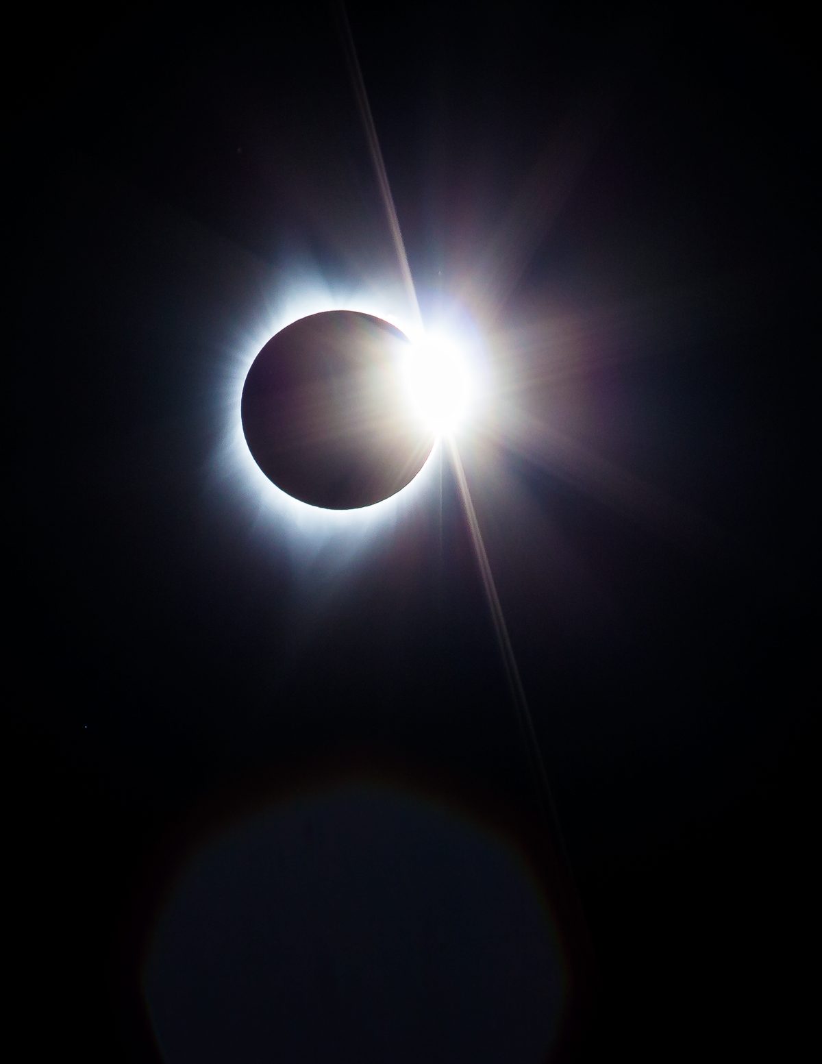 The diamond ring moment of a total solar eclipse, a bright flare on the edge of the black moon.