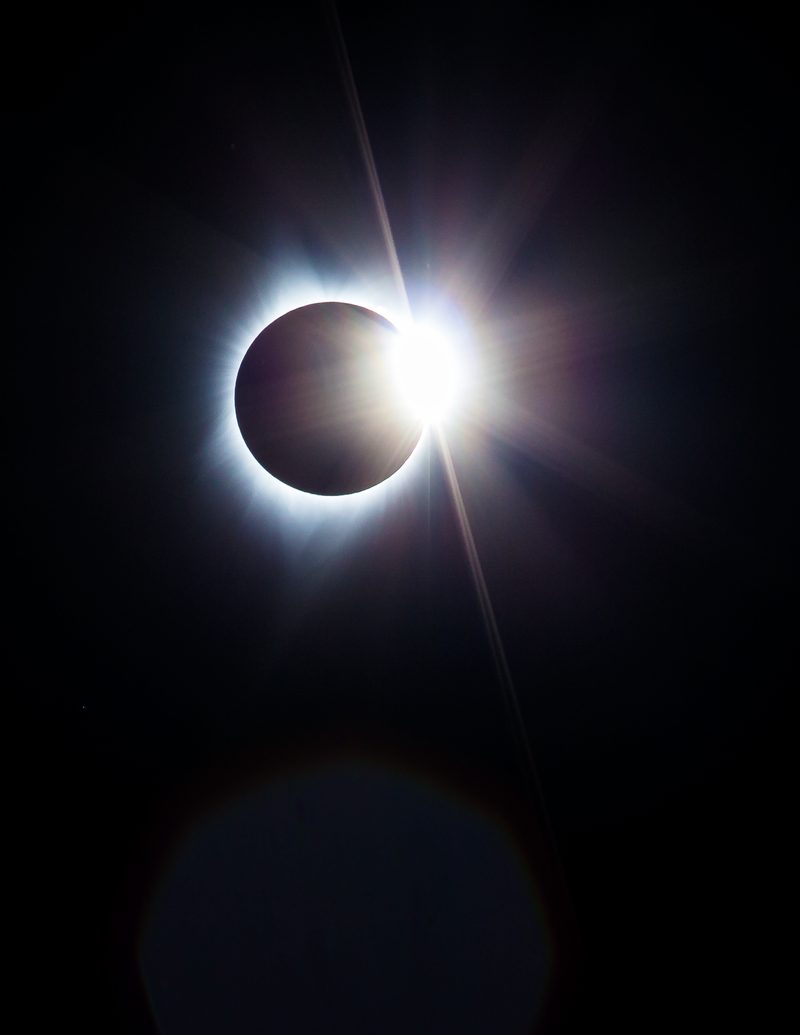 The diamond ring moment of a total solar eclipse, a bright flare on the edge of the black moon.
