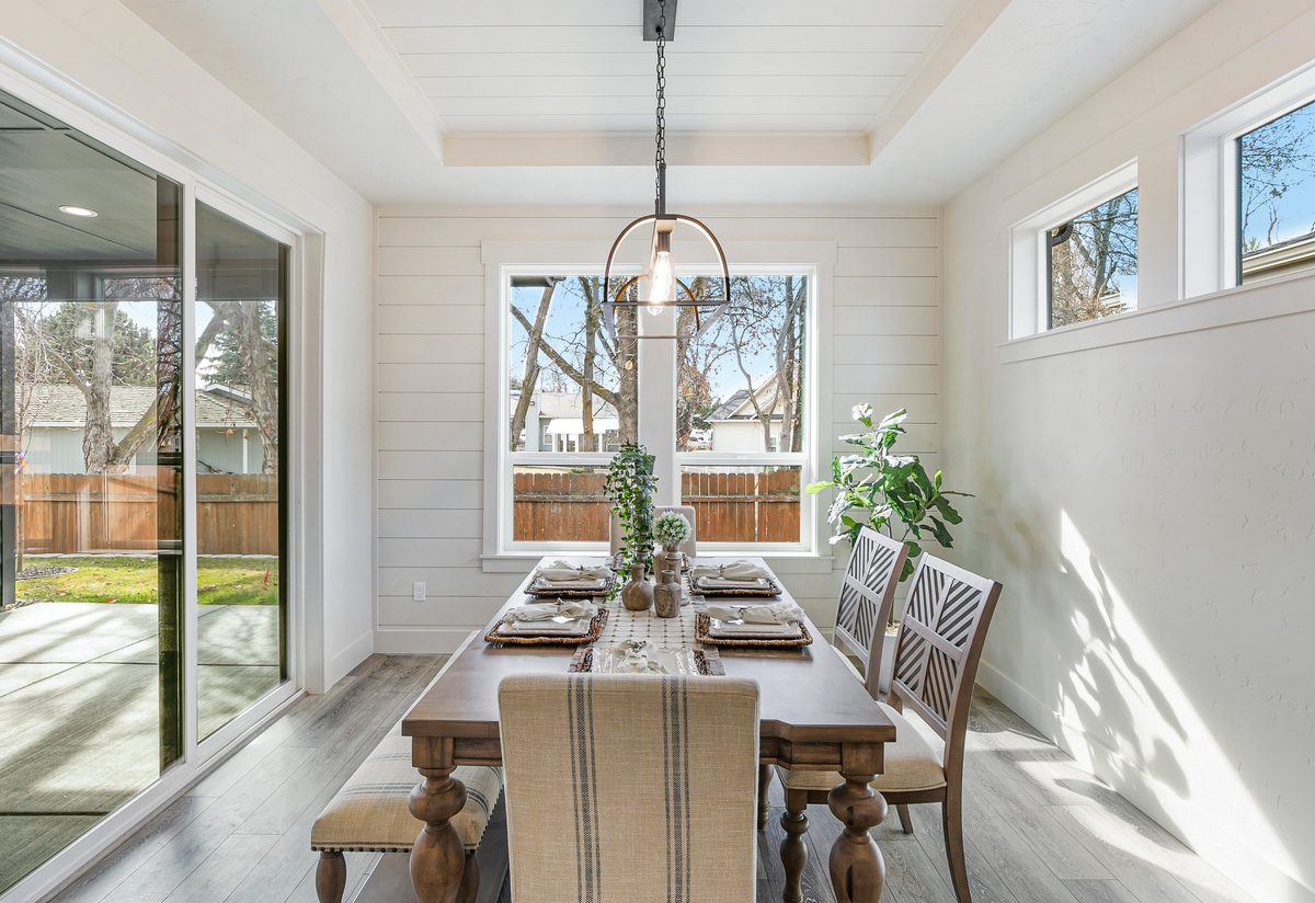 Bright dining room with a long table, a chandelier and sliding glass doors to the yard