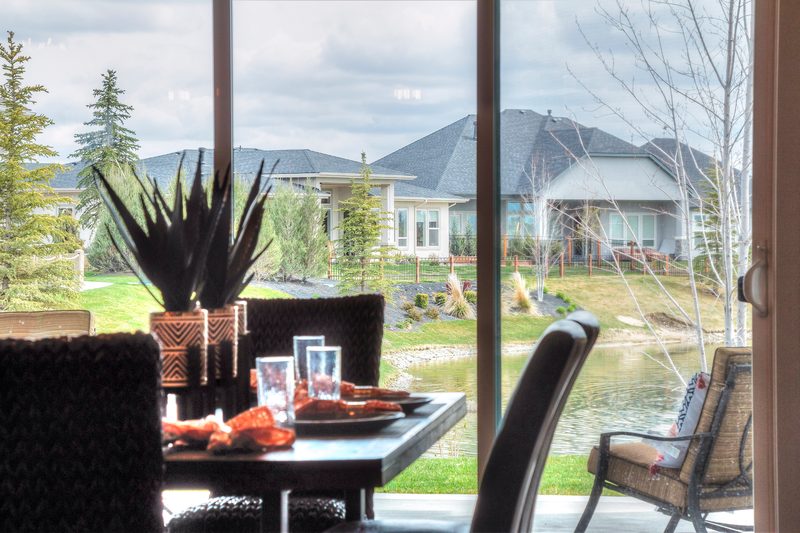 Dining table set for a meal beside sliding doors with a neighborhood and mountain view