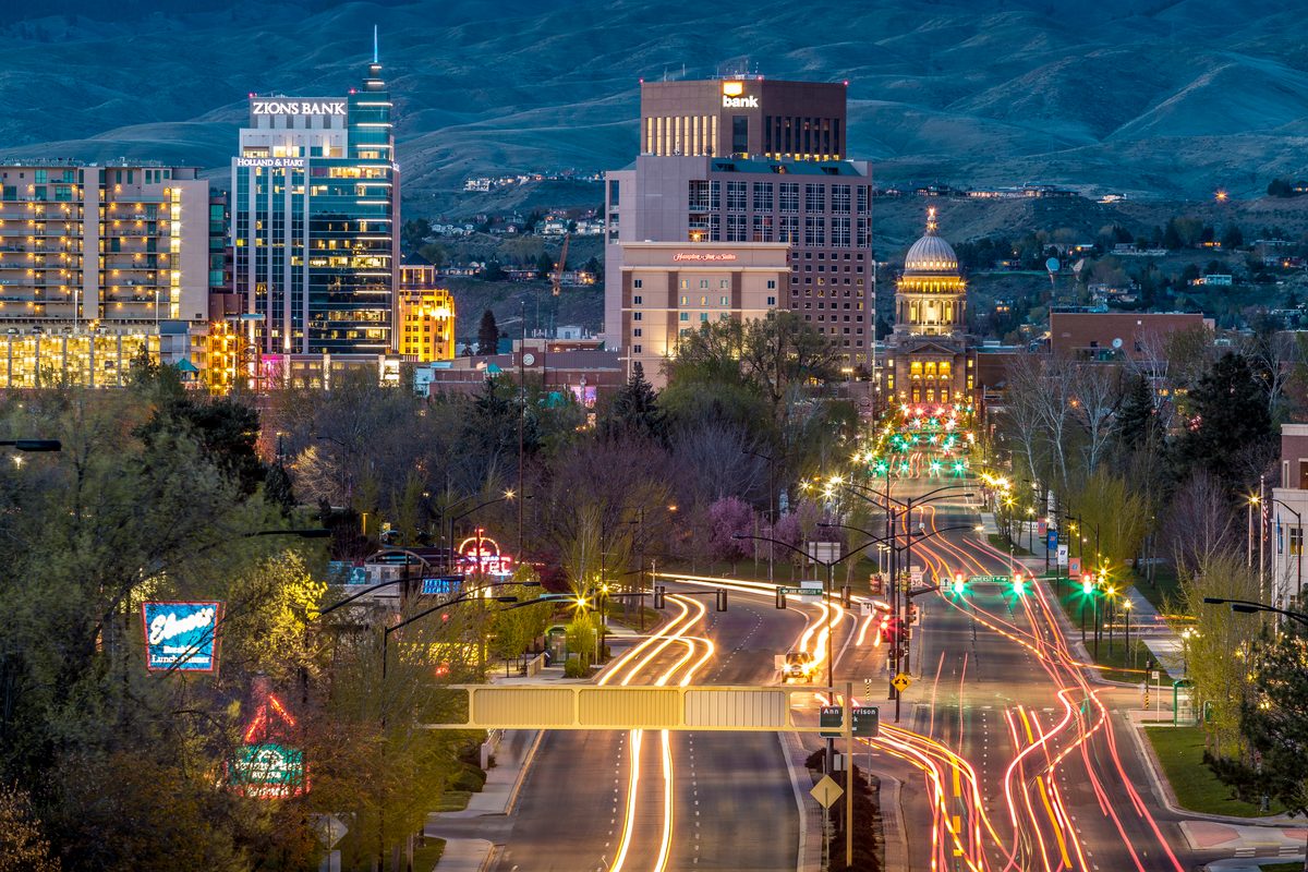 Long-exposure light trails on Capitol Boulevard leading to the Idaho State Capitol and downtown Boise skyline at blue hour