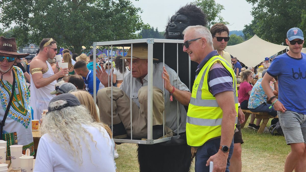 Festival-goers gathered around a staff member in a hi-vis vest