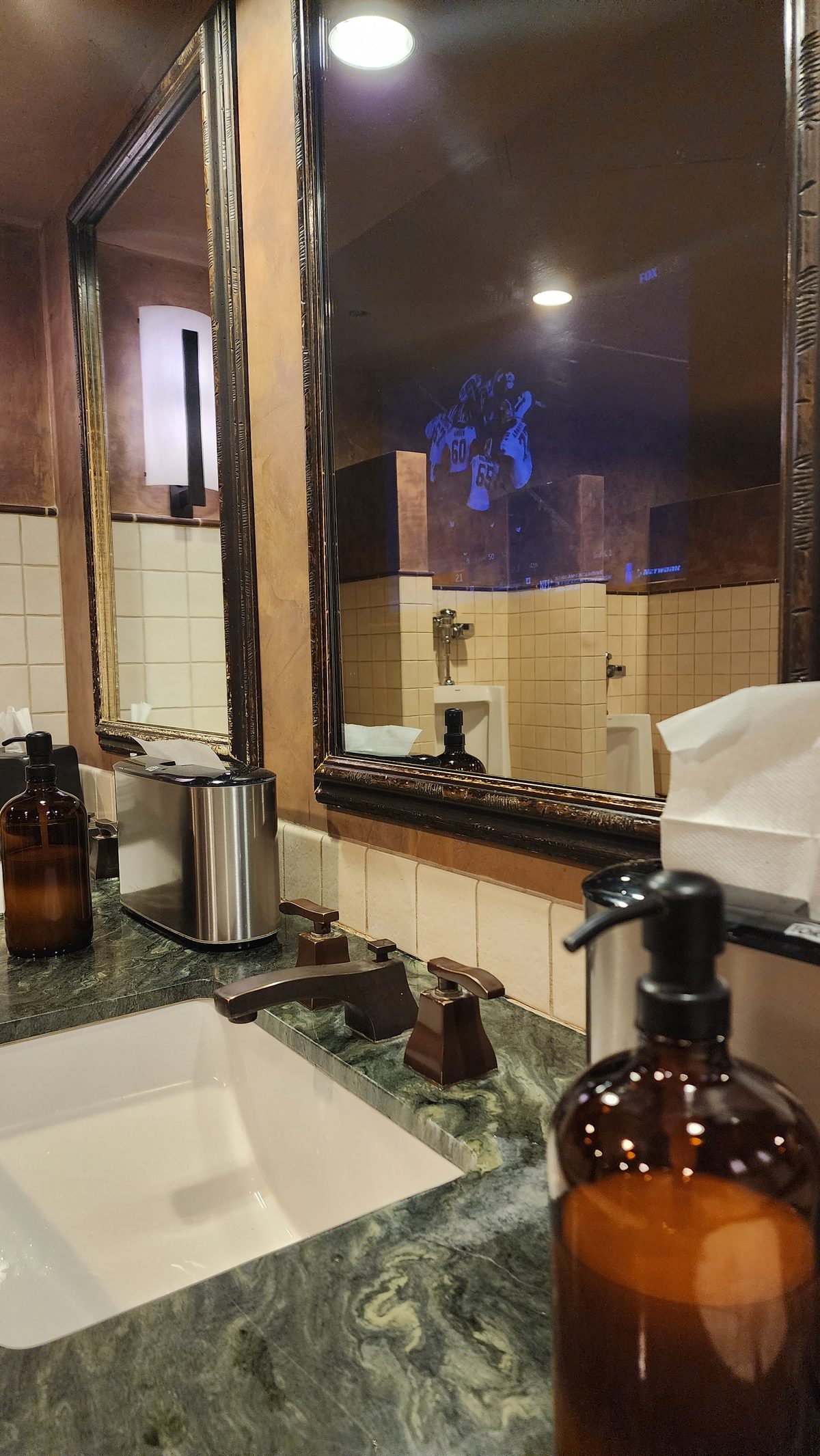 A marble hotel bathroom sink with amber soap bottles