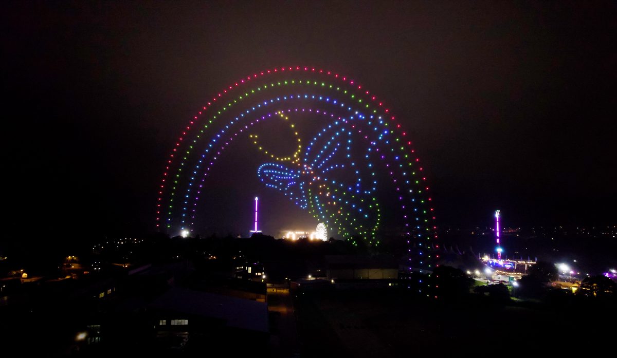 A colorful drone light show over the Isle of Wight Festival at night