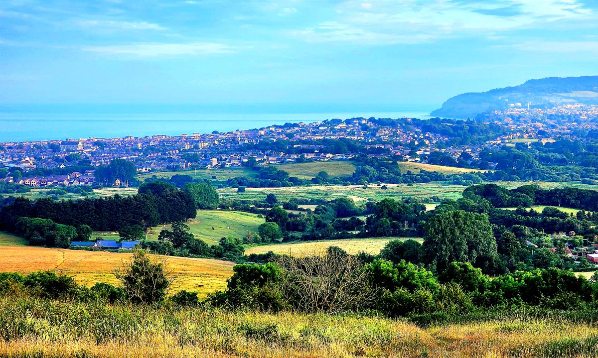 A wide view over green fields and towns to the sea on the Isle of Wight