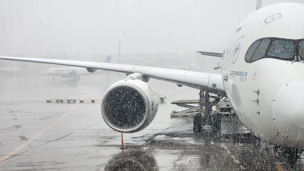 A close view of an airliner's jet engine on a gray tarmac
