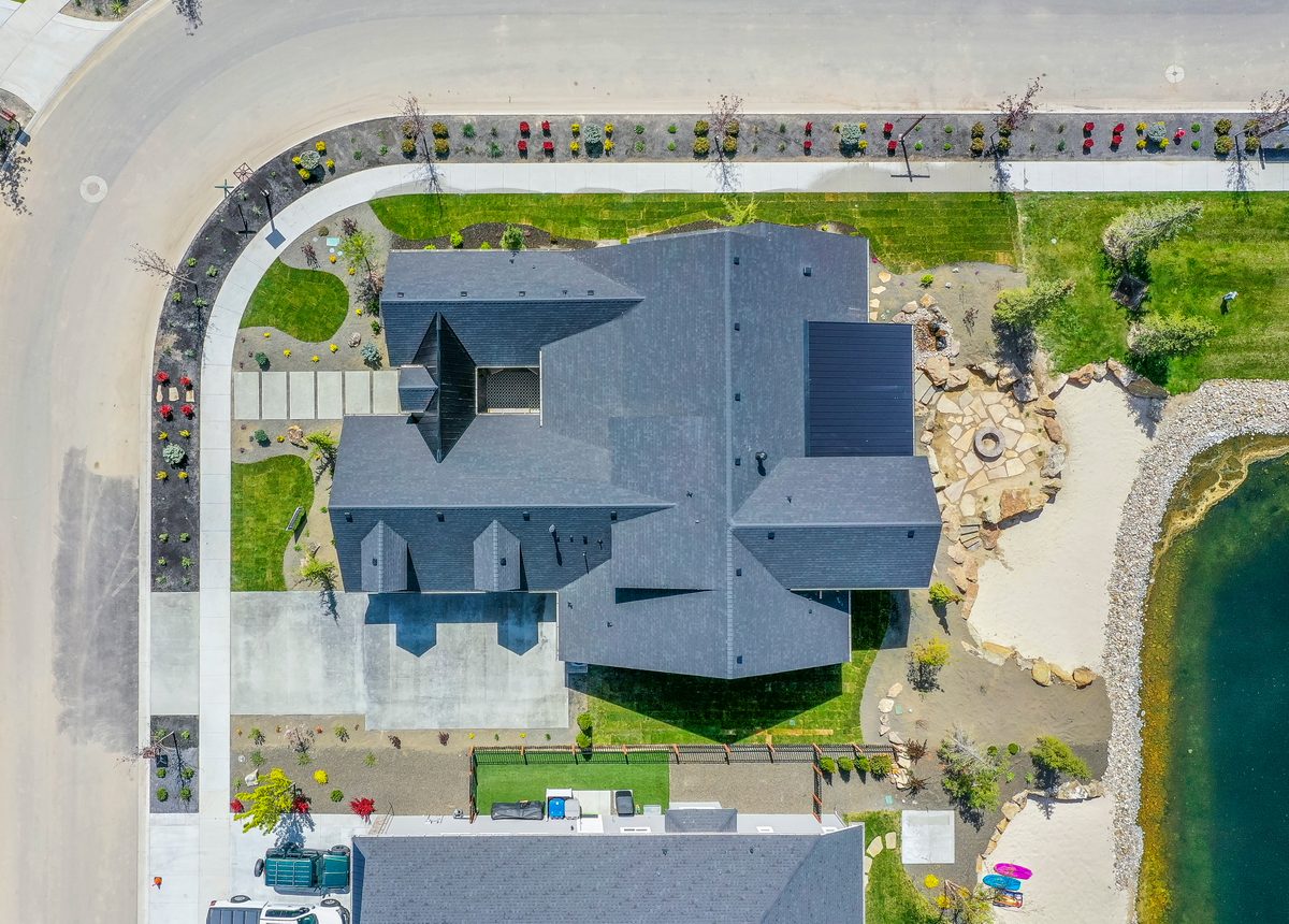 Top-down drone photo of a home on a curving lakeside lot