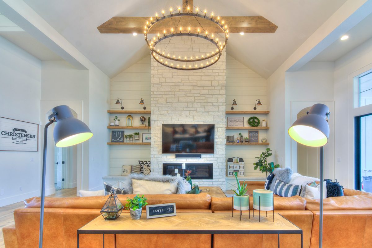 Bright living room with a ring chandelier, fireplace and floor lamps