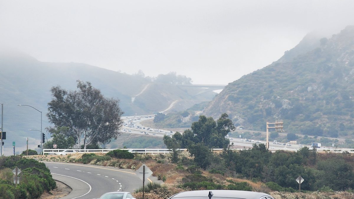 Fog drifting over coastal hills and a winding road