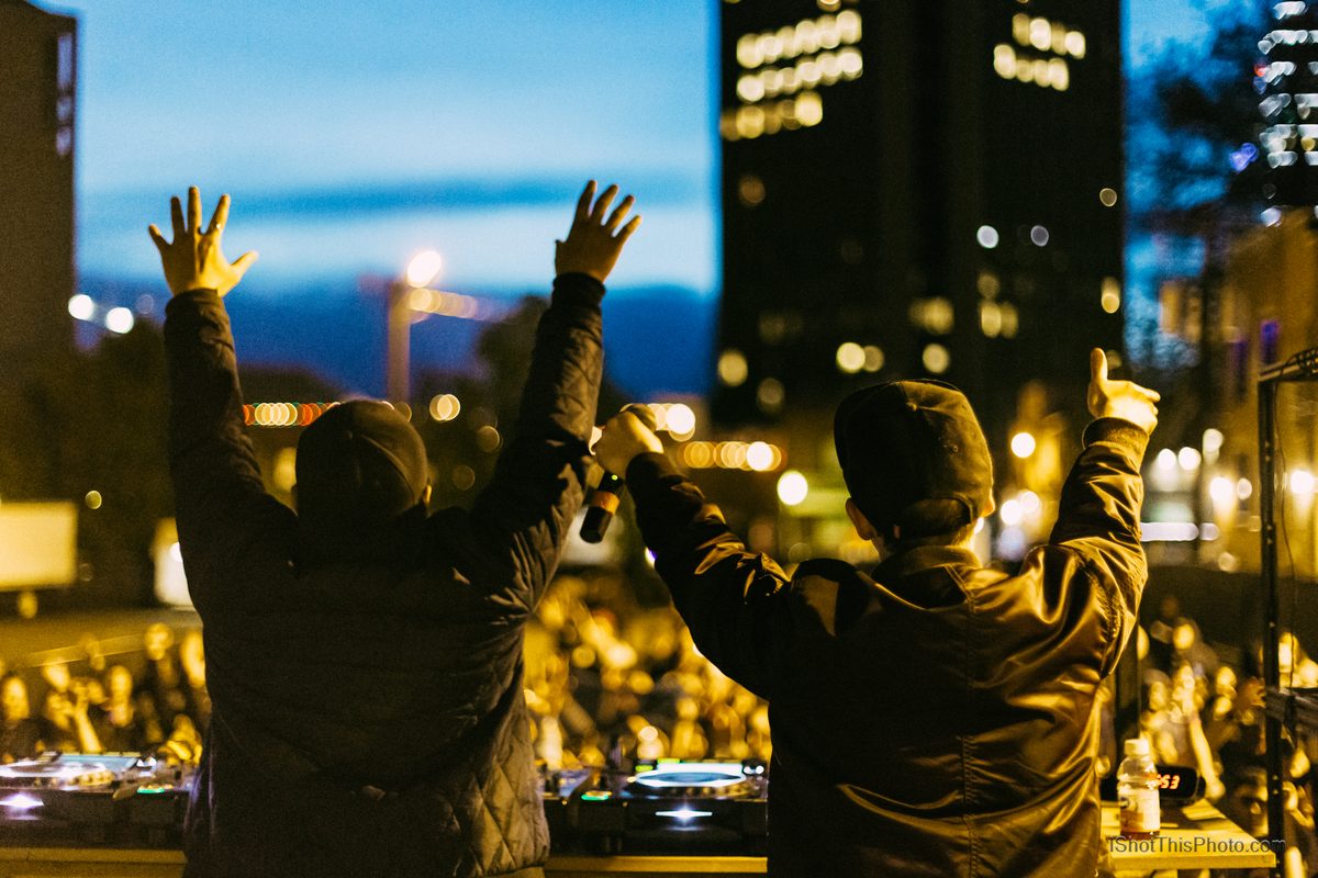 The duo Mt Eden raising their hands to a packed crowd at dusk during Gravity Electronic Music Festival in Boise