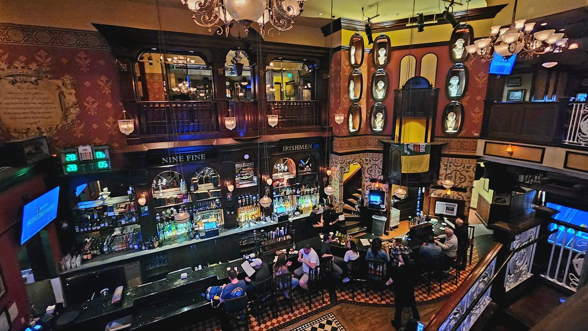 An ornate casino bar with carved wood and glowing screens