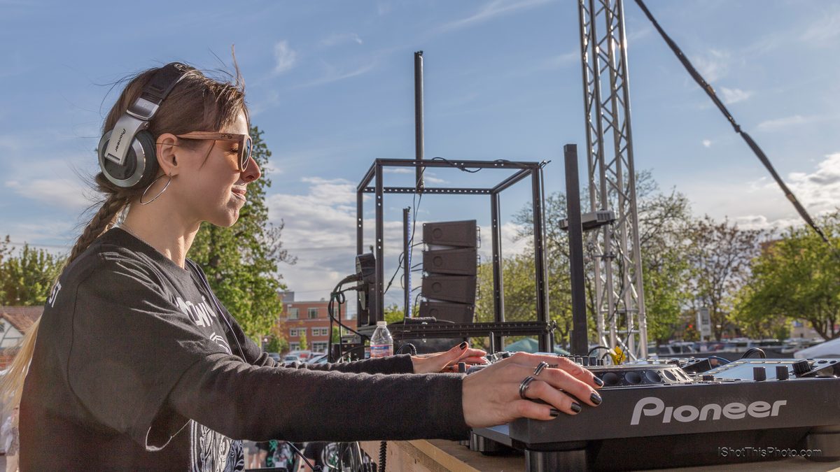 DJ Reid Speed in headphones at the decks in afternoon sun at Gravity Electronic Music Festival, Boise