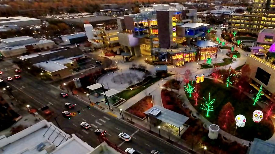 Drone orbits downtown Boise in holiday lights, then a snowy ski lodge and lift, then the campus at dawn