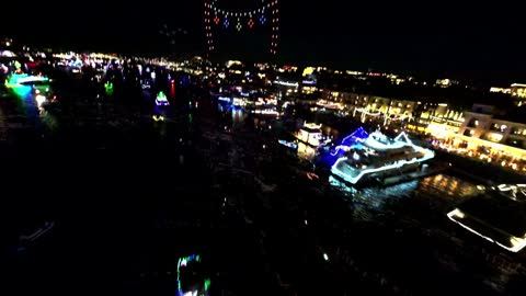 FPV flight over lit-up boats in a night-time Christmas boat parade
