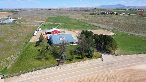 Drone flight around a white farmhouse, red barn and horse arena on farmland