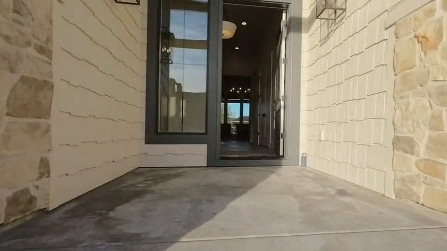 FPV drone glides from a great room out to a fountain pond and waterfall garden